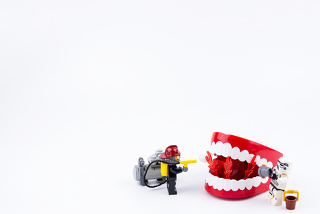 Nonthabure, Thailand - May, 17, 2017 : Lego Fireman and Lego stormtrooper helping extinguish the fire in the red plastic chattering teeth isolated on white background.のeditorial素材