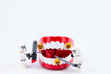 Nonthabure, Thailand - May, 17, 2017 : Lego stormtrooper helping get disinfect of bacteria on red plastic chattering teeth isolated on white background.のeditorial素材