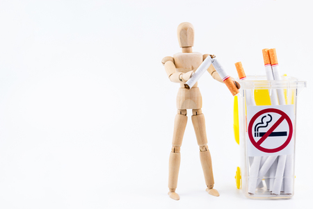 Wooden puppet take the cigarettes to dumps.No Smoking Day background.Anti smokingの写真素材