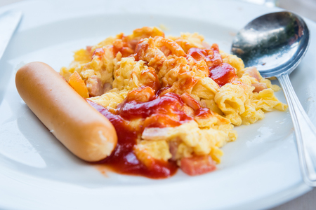 Omelet, grilled sausages, tomato on a white plateの写真素材
