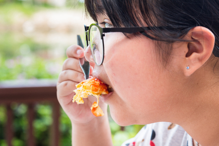 Trat, Thailand - May, 21, 2017 : Close up of a teen woman hands eating delicious breakfast with Scrambled eggs and Sausage at Klong Prao Resort in Koh Chang island Trat, Thailand.のeditorial素材
