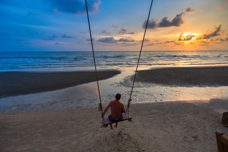 Trat, Thailand - May, 20, 2017 : Unidentified name Father and baby sit on a swing watching the sunset on the beach at Klong Prao Resort in Prao Beach Koh Chang island Trat, Thailand.Concept familyのeditorial素材