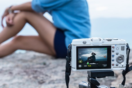 Chaiyaphum, Thailand - July, 01, 2017 : Closeup of olympus camera screen showing a young gir sits on a cliff edge on the top of mountain with gorgeous view at Chaiyaphum, Thailandのeditorial素材