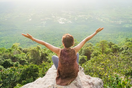 Chaiyaphum, Thailand - July, 01, 2017 : Unidentified name tourist woman sits on a cliff edge on the top of mountain with gorgeous view at Chaiyaphum, Thailandのeditorial素材