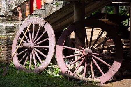 Old wooden wheels of the cart in temple, Thailandの写真素材