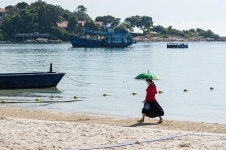 Rayong, Thailand - October, 08, 2017 : Woman holding umbrella walking on Vongdeuan beach morning at the Koh Samet island, Rayong, Thailandのeditorial素材