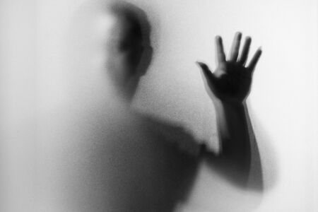 Shadow blur of horror man.Dangerous man behind the frosted glass.Mystery man.Black and white...