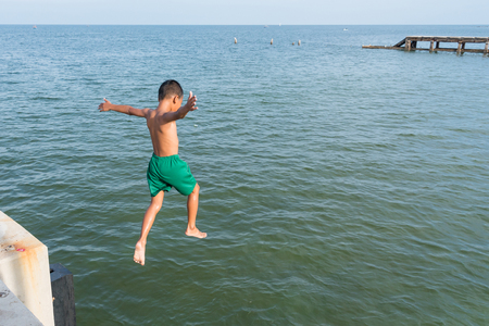 Prachuab Khirikhan, Thailand - October, 13, 2017 : Boys swimming, jumping into the sea from a jetty at Hua Hin beach Prachuab Khirikhan,Thailandのeditorial素材