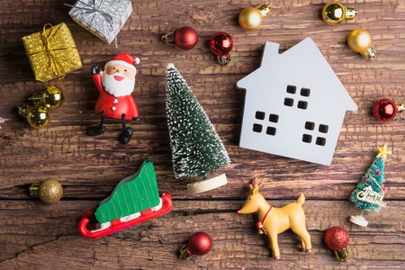 Wooden house toy and christmas decorations on wooden background with copy space.Christmas day conceptの写真素材