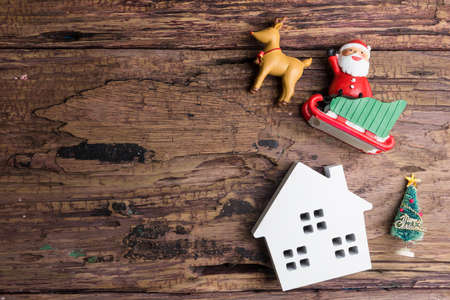 White wooden house toy and christmas decorations on wooden background with copy space.Christmas day conceptの写真素材