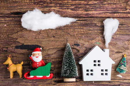 White wooden house toy and christmas decorations on wooden background with copy space.Christmas day conceptの写真素材