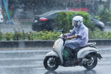 Nonthaburi, Thailand - November, 16, 2017 : Motion Blurred panning photo of Unidentified name people riding motorcycle in the rain on road at Nonthaburi, Thailand.のeditorial素材