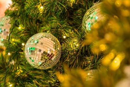 Many mirror balls decorate on green leaves tree and lighting system in a department store in greeting season such as Christmas and New Year festival.Bokeh light backgrounds in Christmasの写真素材