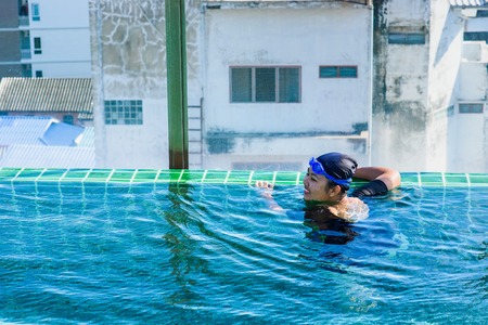 Prachuab Khirikhan, Thailand - November, 25, 2017 : Teenage girls are swimming in the hotel's rooftop pool of the hotel Hua Hin city at Prachuab Khirikhan, Thailand.のeditorial素材