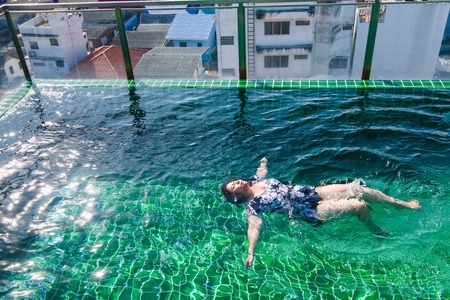Prachuab Khirikhan, Thailand - November, 26, 2017 : Woman are swimming in the hotel's rooftop pool of the hotel Hua Hin city at Prachuab Khirikhan, Thailand.のeditorial素材