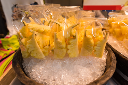 Fresh pineapples slices in plastic bags in Thailand street marketの写真素材