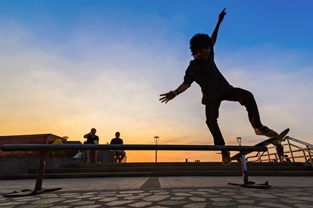 Samut Prakan, Thailand - December, 24, 2017 : Unidentified name man playing skateboard in park by the dam sunset time at Samut Prakan, Thailand.のeditorial素材