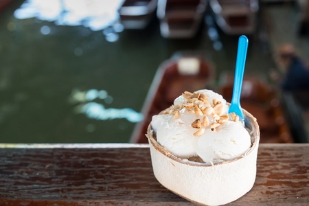 Coconut ice cream. Sweet coconut ice cream in the fresh coconut and plastic spoon. coconut ice cream is very popular dessert in market.Thailandの写真素材