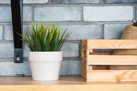 Coffee cafe decoration with tree pots, wooden box, bag and glass of coffee on shelf.Thailandの写真素材