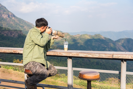 Phitsanulok, Thailand - January, 21, 2018 : Unidentified name Man Take a picture with Dslr professional camera and len super tele photo, outdoor photography in wildlife at Phetchabun, Thailandのeditorial素材