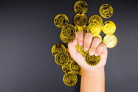 Cryptocurrency golden bitcoins coin in girl hand. Electronic virtual money for web banking and international network payment. Symbol of crypto currencyの写真素材