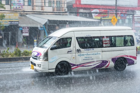 Nonthaburi, Thailand - February, 19, 2018 : Rainwater spraying from motion car wheels. city road...
