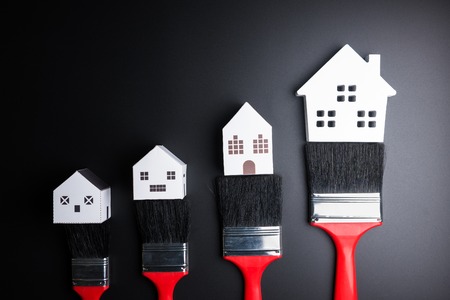 White house toy and paint brush on black background with copy space.Real estate concept, New house concept, Finance loan business concept, Repair maintenance conceptの写真素材