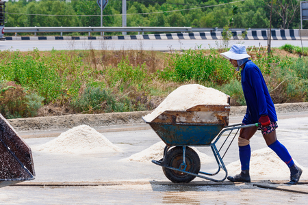 Samutsakhon,Thailand - March, 24, 2018 : Unidentified name workers picking up, collecting the salt, in big salt fields, manual labour, organic agriculture, very hard job at Samutsakhon,Thailandのeditorial素材