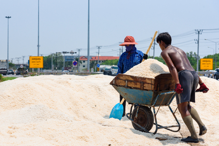 Samutsakhon,Thailand - March, 24, 2018 : Unidentified name workers picking up, collecting the salt, in big salt fields, manual labour, organic agriculture, very hard job at Samutsakhon,Thailandのeditorial素材