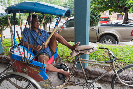 Lop Buri, Thailand - April, 29, 2018 : Unidentified name old man tricycle bicycle taxi waiting for customers on the street Lop Buri railway station at Lop Buri, Thailandのeditorial素材