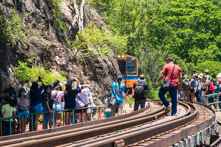 Kanchanaburii, Thailand - May, 13, 2018 : World war II historic railway, known as the Death Railway with a lot of tourists on the train taking photos of beautiful views at Kanchanaburii, Thailandのeditorial素材