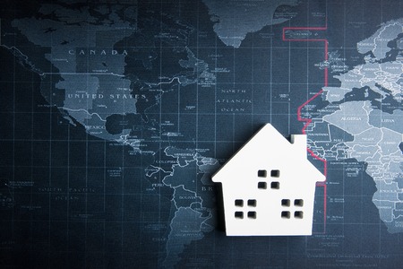 Wooden white house model on the world map.Real estate concept, New house conceptの写真素材