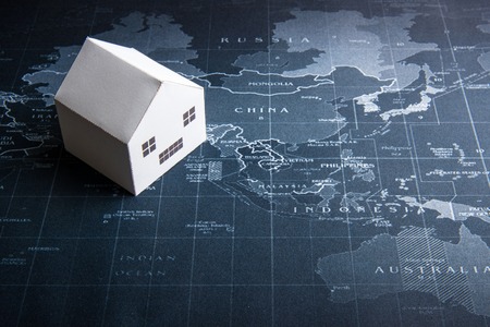 Paper white house model on the world map.Real estate concept, New house conceptの写真素材