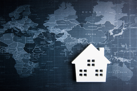 Wooden white house model on the world map.Real estate concept, New house conceptの写真素材