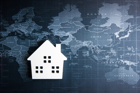 Wooden white house model on the world map.Real estate concept, New house conceptの写真素材