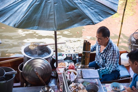 Ratchaburi,Thailand - June, 02, 2018 : Unidentified man sell noodle on the boat at traditional floating market, Ratchaburi, Thailandのeditorial素材
