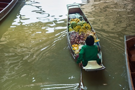 Ratchaburi,Thailand - June, 02, 2018 : Unidentified old woman vendor fruit floats in a boat at Damnoen Saduak floating market Ratchaburi, Thailand.のeditorial素材