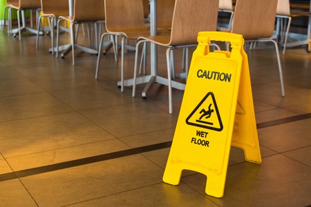 Yellow sign that alerts for wet floor in the restaurant.Thailandの写真素材