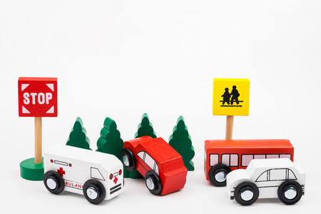 Wooded toy car are crashed. Accident road traffic with wooden toy cars in the town on white background, safety and traffic regulations concept, backgrounds.Transportation system conceptの写真素材