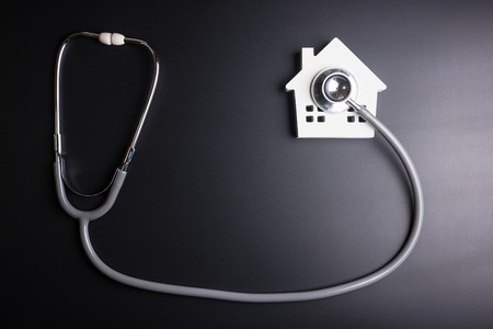 House model with stethoscope isolated on black background.Indicates the health of the houseの写真素材