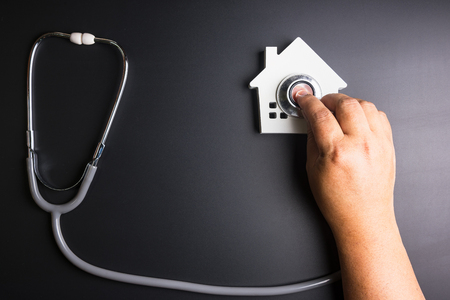 House model with stethoscope isolated on black background.Indicates the health of the house.の写真素材