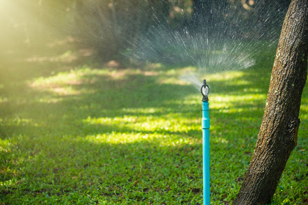 Automatic sprinkler system watering the lawn on a background of green grass.Thailandの写真素材
