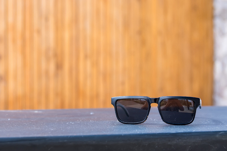 Black sunglasses on wood table.Thailandの写真素材