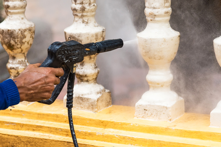 Cleaning terrace with a power washer, high water pressure cleaner on cement terrace surfaceの写真素材