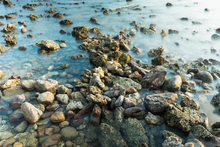 Waves on stone beach waters edge abstract sea background.Thailandの写真素材