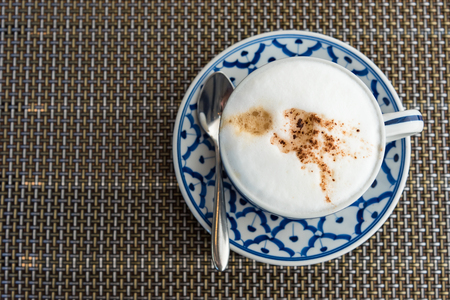 Hot cappuccino coffee in cup on the wooden tableの写真素材