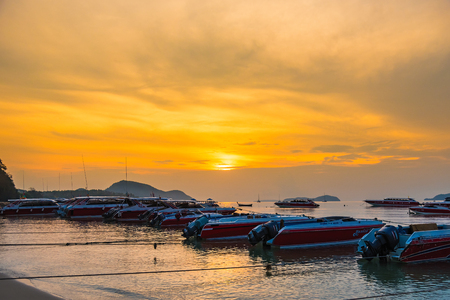 Phuket, Thailand - March, 31, 2019 : Sunrise above Tour boat on the beach. morning light shines up from the edge of the sea. A reflection on Tour boat parked on Rawai beach.Phuket, Thailandのeditorial素材