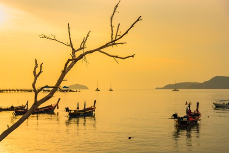 Phuket, Thailand - March, 31, 2019 : Sunrise above Tour boat on the beach. morning light shines up from the edge of the sea. A reflection on Tour boat parked on Rawai beach.Phuket, Thailandのeditorial素材