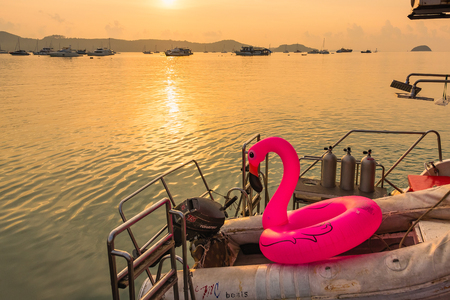 Phuket, Thailand - March, 30, 2019 : Pink flamingo swim tube on the back of the boat tour in sunrise morning  at Chalong port, Main port for travel ship to krabi and phi phi island, Phuket, Thailandのeditorial素材