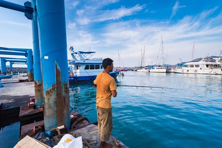 Phuket, Thailand - March, 30, 2019 : Unidentified name Man standing sea fishing at Chalong port, Main port for travel ship to krabi and phi phi island, Phuket, Thailandのeditorial素材